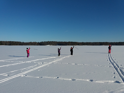Lapset hiihtävät järven jäällä.