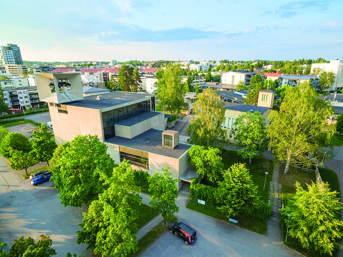 Kirkko Järvenpään betonikirkko ylhäältäpäin kuvattuna.